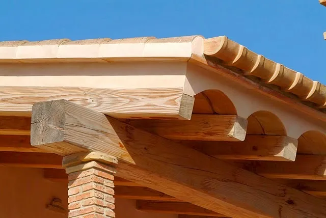 Canalón cerámico artesanal instalado bajo una cubierta de teja sobre estructura de madera.
